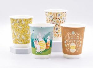 Four Easter paper cups with unique designs featuring bunnies, chicks, and spring patterns, available at papercupcompany.com